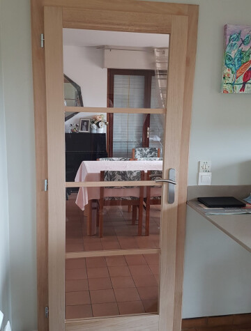 Porte intérieure vitrée bois clair, ouvrant sur la salle à manger