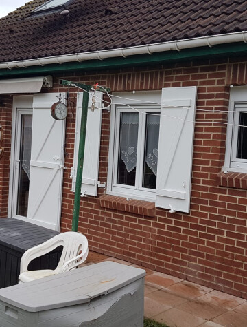 Pavillon en brique, volets battants blancs et fenêtres blanches