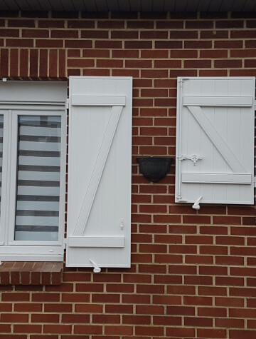 Fenêtres blanches et volets battants blancs, façade en brique