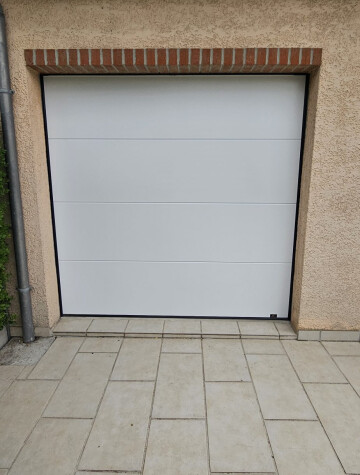 Porte de garage blanche, encadrement en brique