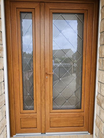 Porte d’entrée vitrée à deux vantaux, finition bois, vitrage à motifs losange