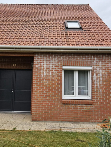 Deux portes de garage sombres sur maison en brique