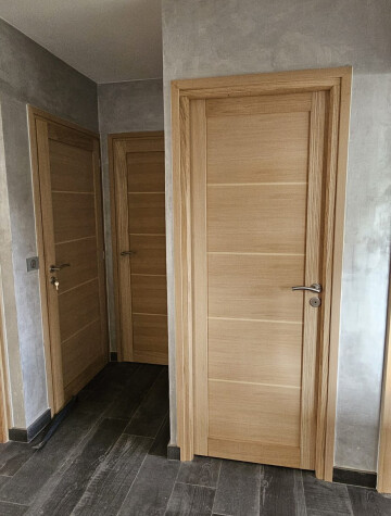 Porte intérieure bois clair, sol en parquet gris